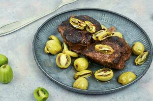 Grilled ostrich steak with kiwi berries photo