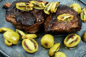 Grilled ostrich steak with kiwi berries photo