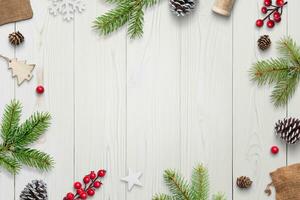 Top view of festive white wooden desk with Christmas decorations, gifts, and copy space. Elegant holiday composition photo