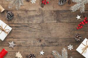 Christmas desk with festive decorations, tree branches, gifts, and copy space. Wood background with holiday atmosphere photo