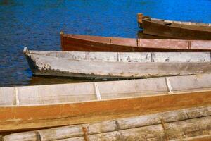 traditional wooden flat-bottomed boats on the river bank, rural landscape photo