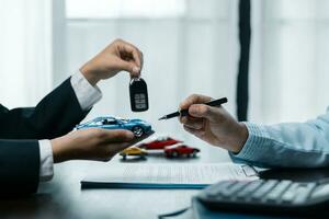 Toy Car In Front Of Businessman Calculating Loan. Saving money for car concept, trade car for cash concept, loan finance concept. photo