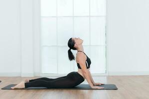 Beautiful young woman practicing yoga at home. Yoga asana. photo