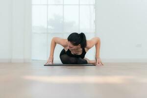 Beautiful young woman practicing yoga at home. Yoga asana. photo