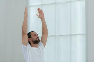 Beautiful young man practicing yoga at home. Yoga asana. photo