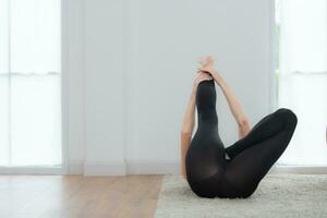 Beautiful young woman practicing yoga at home. Yoga asana. photo