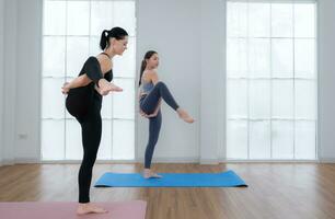 Young woman practicing yoga with instructor in house. Individual yoga class practicing in house photo