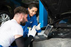 profesional auto mecánico hombre y mujer trabajando juntos en auto reparar tienda. foto