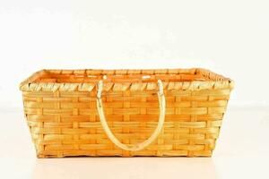 a wicker basket with handles on a white surface photo