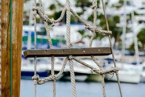 a rope is tied to a wooden pole in front of a marina photo