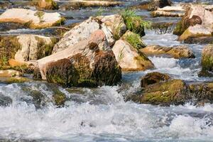 un río con rocas y agua fluido terminado ellos foto