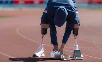 discapacitado Atletas preparar en comenzando posición Listo a correr en estadio pista foto