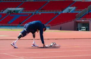 discapacitado atlético hombre extensión y calentamiento arriba antes de corriendo en estadio pista foto