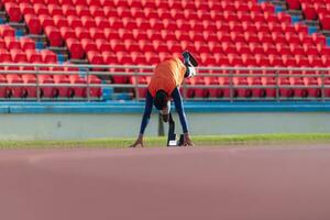 discapacitado Atletas preparar en comenzando posición Listo a correr en estadio pista foto
