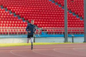 Athletes with disabilities who utilize running blades for short distances. Run down the running track. photo