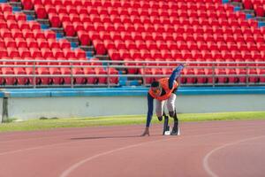 discapacitado Atletas preparar en comenzando posición Listo a correr en estadio pista foto