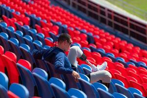 Disabled athletes prepare their bodies on amphitheater in a sports arena on a sunny day before entering a short-distance running competition photo