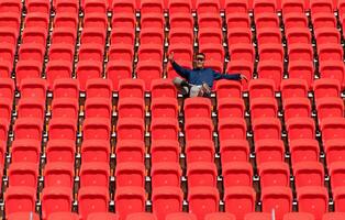 Disabled athletes in a blue shirt sitting on the red seats at the stadium, Prepare for running training. photo