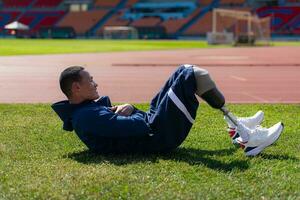 Disabled athletic man stretching and warming up before running on stadium track photo