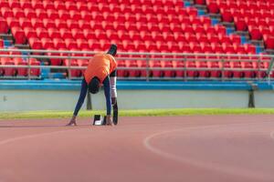 Disabled athletes prepare in starting position ready to run on stadium track photo