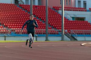 Athletes with disabilities who utilize running blades for short distances. Run down the running track. photo