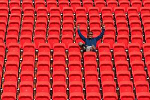 discapacitado Atletas en un azul camisa sentado en el rojo asientos a el estadio, preparar para corriendo capacitación. foto