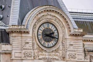 el reloj en el lado de el edificio es en el forma de un reloj foto