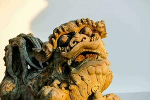 un estatua de un chino león con sus boca abierto foto