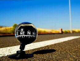 a black and white compass on the side of a road photo