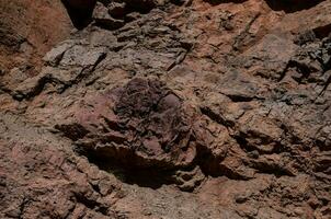 a rock face with a large rock in the middle photo