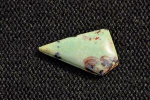 a green and red stone with a triangular shape photo
