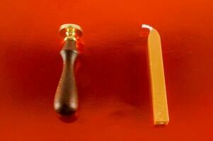 a wooden and brass stamper and a candle photo