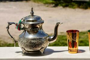 a silver tea pot and two cups on a table photo