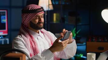 Arabisch Mens controle omhoog Aan dichtbij vriend gedurende video conferentie vergadering over- de telefoon. midden- oostelijk persoon genieten van tijd samen met vriend in online video telefoontje sessie gebruik makend van smartphone