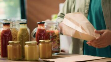 Adding pasta in paper bag to buy enough for nutritious supper, choosing organic pantry supplies from bulk products in recyclable containers. Customer goes shopping for food items. Handheld shot. video