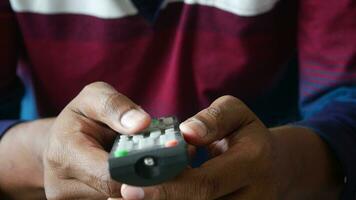 close up of man hand holding tv remote. video