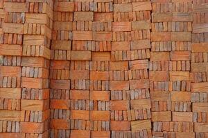 Red brick packed in stacks are stored on ground outdoors at a hardware store warehouse photo