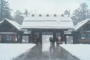 Hokkaido jingu santuario con nieve en invierno estación, japonés budismo sintoísmo templo. punto de referencia y popular para atracciones en Hokkaidō, Japón. viaje y vacaciones conceptos foto