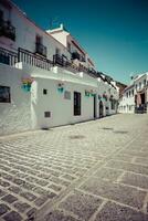 Picturesque street of Mijas with flower pots in facades. Andalusian white village. Costa del Sol. Southern Spain photo