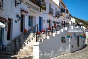 Picturesque street of Mijas with flower pots in facades. Andalusian white village. Costa del Sol. Southern Spain photo