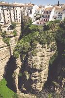 view of buildings over cliff in ronda, spain photo