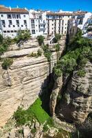 view of buildings over cliff in ronda, spain photo