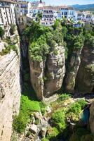 view of buildings over cliff in ronda, spain photo