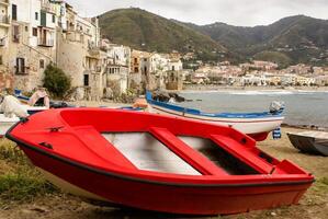 Sicilian fishing boat on the beach in Cefalu, Sicily photo