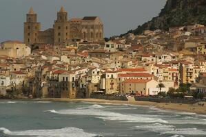 Houses along the shoreline and cathedral in background, Cefalu, Sicily photo