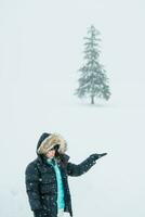 Woman tourist Visiting in Biei, Traveler in Sweater sightseeing Christmas tree with Snow in winter season. landmark and popular for attractions in Hokkaido, Japan. Travel and Vacation concept photo