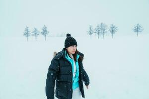 mujer turista visitando en Bien, viajero en suéter Turismo templado Siete colinas con nieve en invierno estación. punto de referencia y popular para atracciones en Hokkaidō, Japón. viaje y vacaciones concepto foto