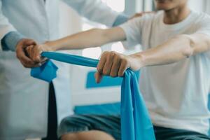 Doctor or physical therapist examines back pain and spinal area to give advice within the rehabilitation center. photo