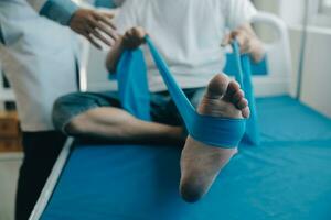 Doctor or physical therapist examines back pain and spinal area to give advice within the rehabilitation center. photo