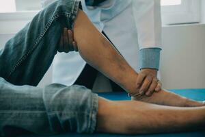 Doctor or physical therapist examines back pain and spinal area to give advice within the rehabilitation center. photo